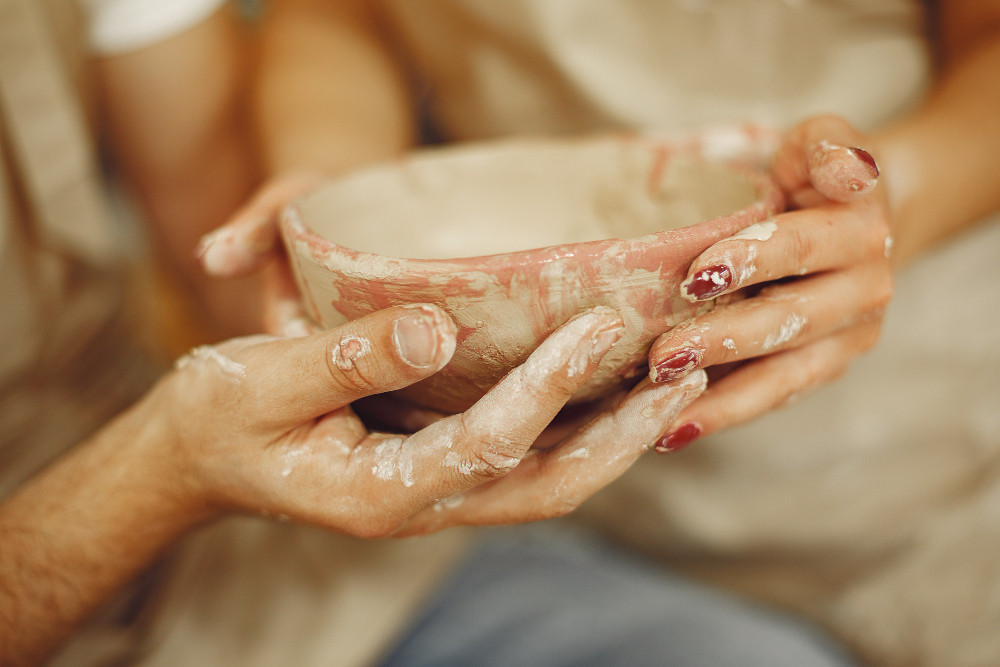 Hands crafting a pottery piece